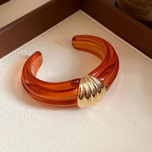 Vintage-Armreif aus bernsteinfarbenem Harz mit Rippenstruktur und goldenem Muschelmotiv