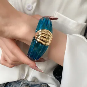 Detailaufnahme: Blaues transparentes Harz-Armband mit goldener strukturierter Muschel