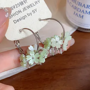 Dettaglio di orecchini a cerchio con fiori in resina e perni in argento S925