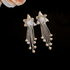 Detailed view of elegant silver flower earrings with zircons and long tassel drops