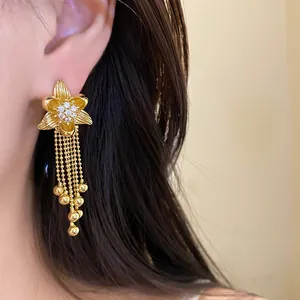 Detailed view of 18k gold plated flower earrings with zirconia and bead tassels