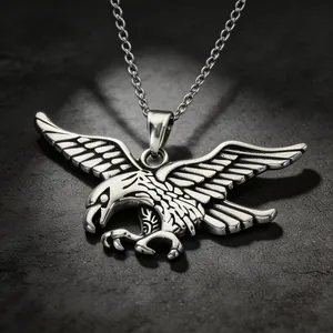 Detailed macro view of a vintage stainless steel flying eagle pendant with tribal engravings.