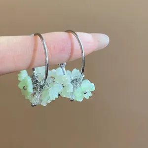 Vista dettagliata di orecchini a cerchio con fiori in resina e perni in argento
