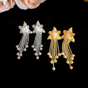 Close-up detail of elegant 18k gold plated flower earrings with zircon tassels.