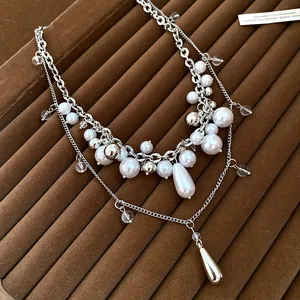 Close-up of multi-layer French style necklace with elegant white pearls and silver chains