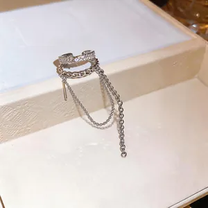 Close-up of a silver double-layer ear cuff with zircon pave and long tassel chains.