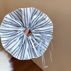 Blue and white striped oversized scrunchie with elegant ribbon bow and silver charm.