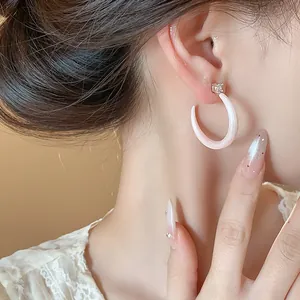 Vista detallada de elegantes pendientes de aro en forma de C de esmalte rosa y circonita