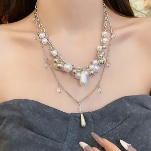 Detailed view of a layered French-style pearl necklace with elegant silver pendants.