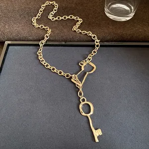 Elegant gold chain necklace featuring a vintage-style key pendant and lock clasp.