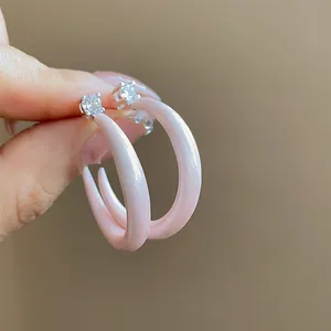 Vista detallada de pendientes de aro en C de esmalte rosa con circonitas brillantes
