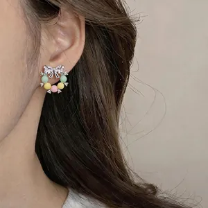 Élégante boucle d'oreille couronne avec perles pastel colorées et accents en zircon étincelant.