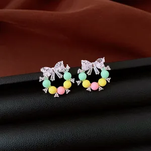 Détail de boucles d'oreilles nœud avec perles colorées et oxydes de zirconium brillants