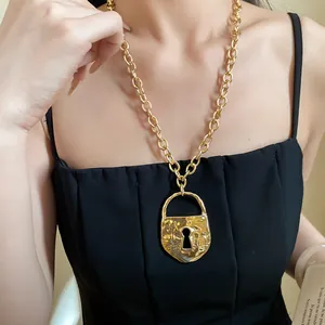 Close-up of a vintage chunky gold chain necklace featuring a textured lock pendant