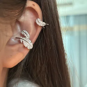 Detailed view of a stylish silver feather ear cuff with shimmering pavé stones on ear