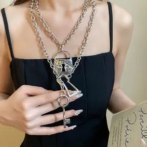 Close-up of vintage silver chain necklace with padlock and key charms worn on neck