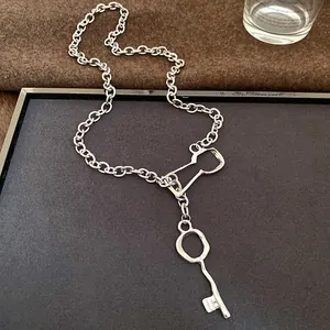 High-quality detail shot of a retro silver metal chain necklace featuring a unique key pendant