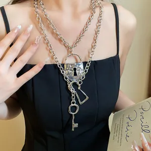 Close-up of vintage layered metal chain necklace with silver lock and key pendants