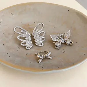 Makroansicht von exquisiten zirkonbesetzten Schmetterlings- und Schleifenclips auf Keramik