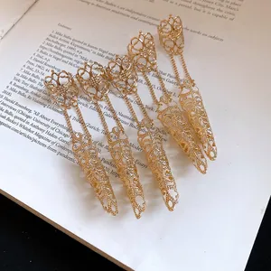 Detailed macro view of gold Gothic hollow finger armor rings featuring delicate chain linkage