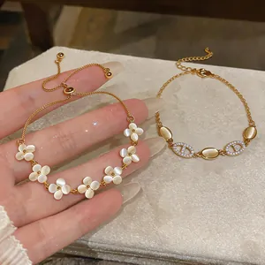 Detailed view of elegant gold-toned cat-eye stone and flower charm bracelets for women