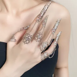 Close-up of Gothic silver filigree finger armor rings with chain detailing.