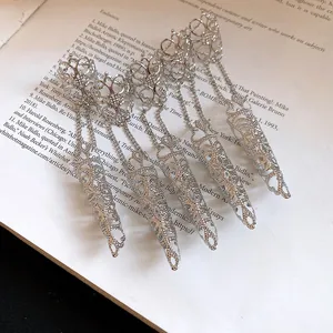 Macro detail of silver Gothic filigree finger armor rings laid on vintage book pages