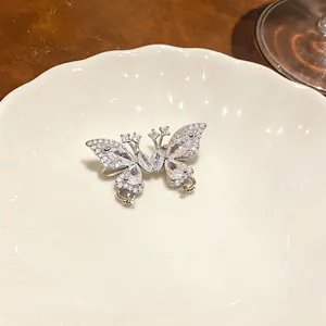 Detailansicht eines eleganten Schmetterling-Ohrclips mit Zirkon auf weißem Porzellan