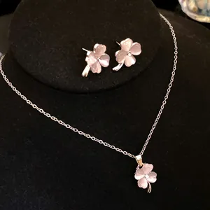 Detailed view of pink cat's eye clover necklace and stud earrings set for women