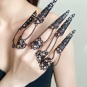 Detailed macro view of gothic black hollowed-out finger armor rings with delicate chains.
