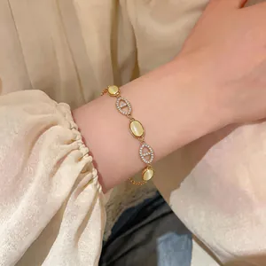 Detail of elegant gold bracelet featuring cat's eye stones and zircon-encrusted links