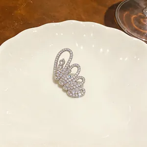 Detailansicht eines silbernen Schmetterlings-Ohrklemmen-Ohrrings mit Zirkonia-Steinen.