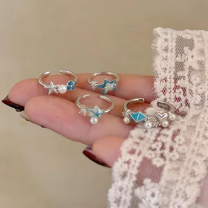 Minimalist sea star and shell open rings set with pearls and blue drip oil finish