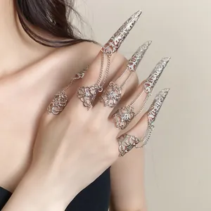 Detailed close-up view of silver gothic hollow claw rings with chains on a model hand