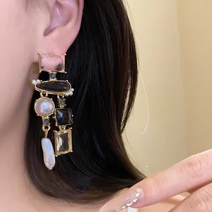 Dettaglio ravvicinato di orecchini vintage stile palazzo con perle e cristalli neri