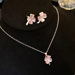 Detailed view of the diamond-set cat's eye stone clover necklace and earring jewelry set