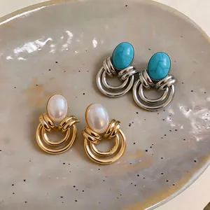 Dettaglio di eleganti orecchini vintage con perle e pietre turchesi in finitura mista