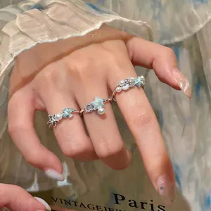 Detailed view of marine-themed rings featuring starfish, shells, and pearls on a hand