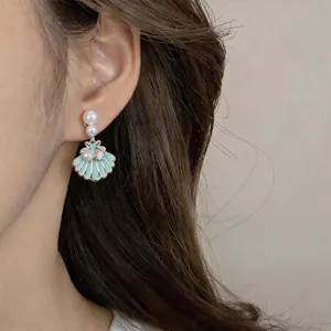 Macro view of mint green enamel shell earring featuring elegant pearl and zircon details.