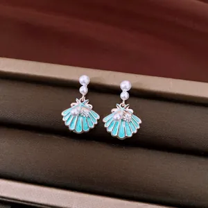 Detail showing enamel seashell earrings with pearls and sparkling zircon accents