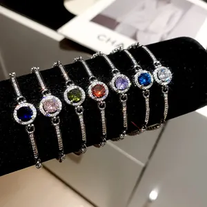Detailed view of sparkling round zircon bracelets in seven vibrant colors on black velvet.