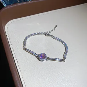 Close-up of sparkling silver bracelet with a pink zircon center and stone-set band