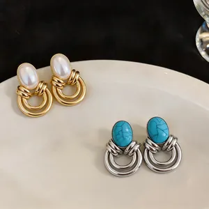 Primo piano di orecchini vintage geometrici con pietre turchesi e perle finte