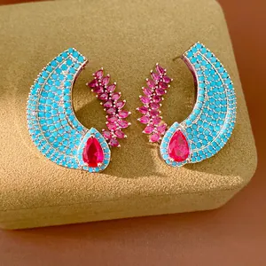Macro view of vintage luxury earrings featuring turquoise beads and red teardrop zircon