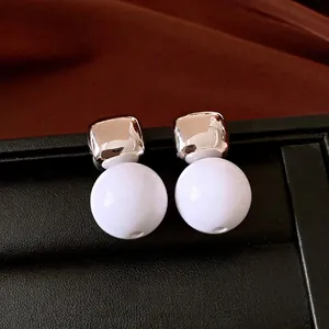 Pendientes minimalistas de resina con agujas de plata, esferas blancas y metal