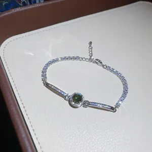Macro view of vintage silver bracelet with sparkling zircons and green center stone