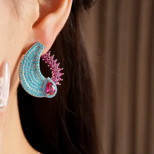 Detailed close-up showing a vintage crescent earring with turquoise beads and pink zircons