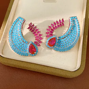 Macro view of vintage style zircon earrings featuring blue pavé and pink pear stones