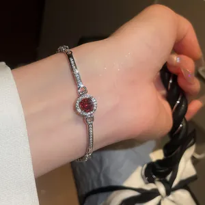 Close-up of luxury vintage silver bracelet featuring a sparkling red zircon center stone
