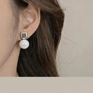 Pendientes de plata con perla de resina blanca en una modelo asiática elegante